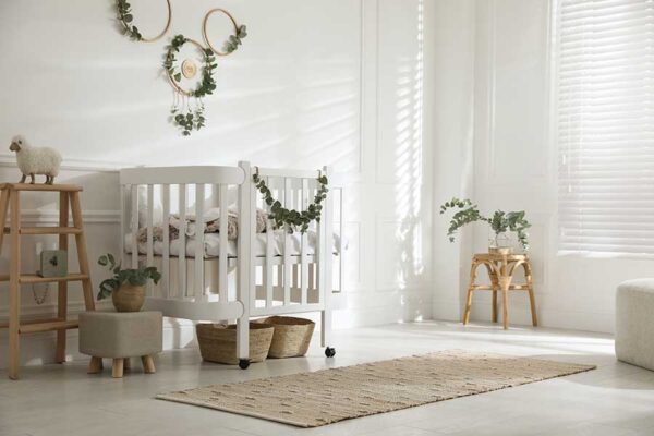 Stylish baby room decorated with eucalyptus branches