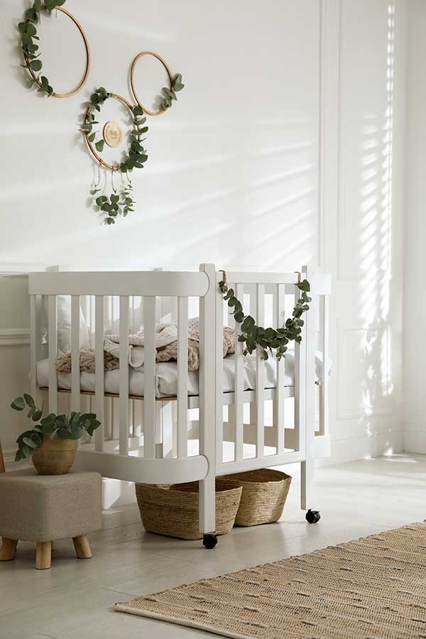 Stylish baby room decorated with eucalyptus branches